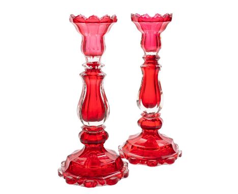 A pair of Bohemian ruby and clear glass candlesticks of faceted baluster form, on stepped bases with lobed rims, late 19th ce