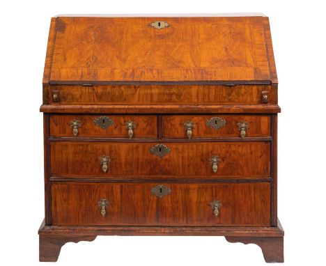 A George I walnut bureau, early 18th century and later; the  rectangular top above a sloping fall front which opens to reveal