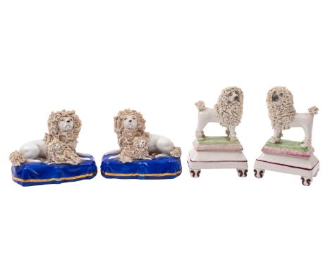 A pair of 19th century Staffordshire pottery miniature models of poodles and a similar pair of French porcelain poodles the f