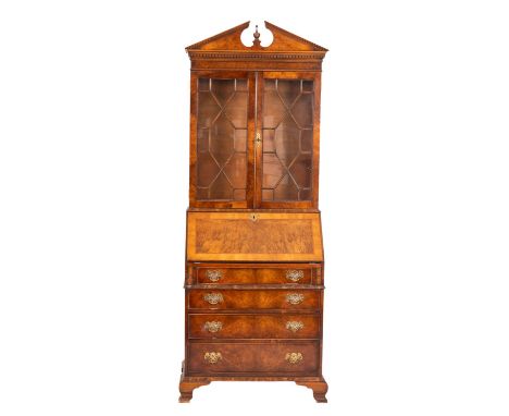 A walnut bureau bookcase in the George III style, 20th Century, the upper part with an architectural moulded broken pediment,