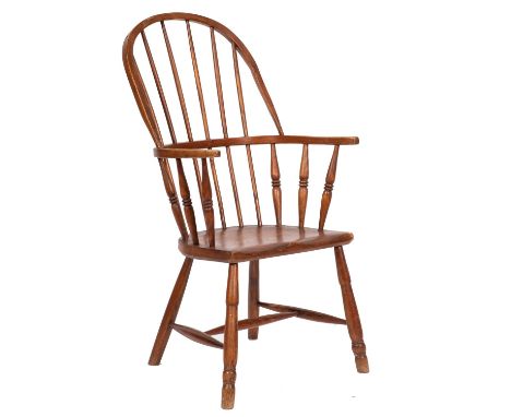 A 19th-century elm and ash stick back Windsor elbow chair; with a shaped solid seat, on turned splayed legs, united by H-stre