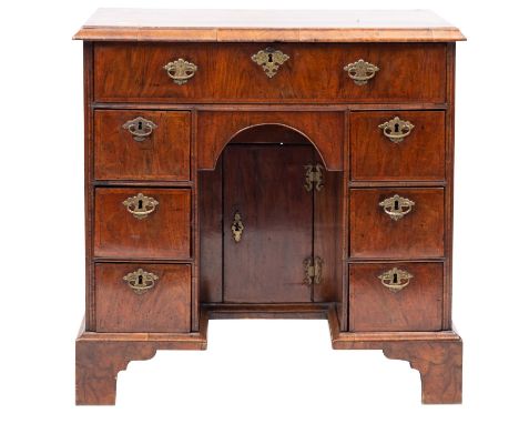 A walnut and feather banded kneehole desk, 18th Century and later, the rectangular top with a moulded edge, fitted with a sin