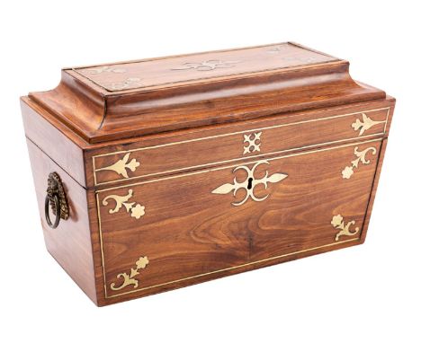 A George IV hardwood, probably padouk and brass inlaid tea caddy, circa 1825; of sarcophagus form, the hinged cover and front