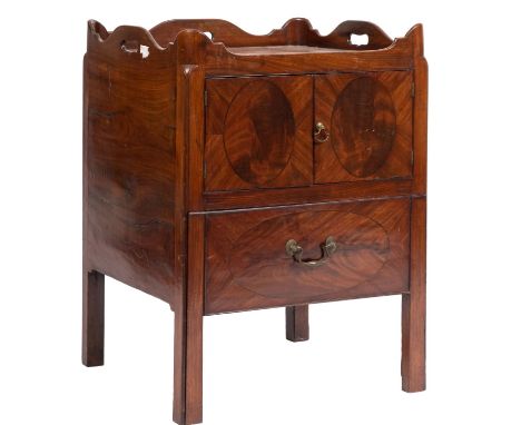 A George III mahogany square tray top commode, the shaped gallery with pierced carrying handles, enclosed by a pair of doors 