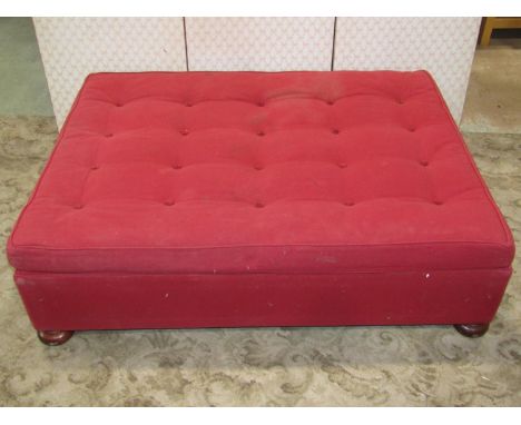 A low upholstered centre stool of rectangular form with button seat cushion and raised on turned bun feet, 120 cm long x 92 c