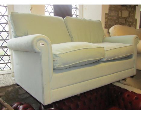 A contemporary two seat sofa with rolled arms, light green upholstered finish and loose feather filled cushion, 166 cm long x