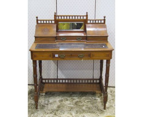 A late Victorian walnut writing desk, the stepped and raised back incorporating a rectangular double edged mirror plate, with