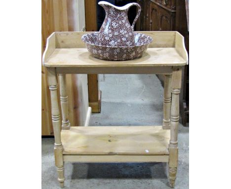 A stripped pine two tier washstand of rectangular form with raised three quarter gallery central cut out bowl receptacle toge