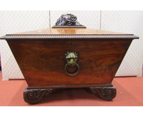 A Regency mahogany sarcophagus shaped wine cooler, raised on four scrolled supports, with fruiting vine trailing decoration, 