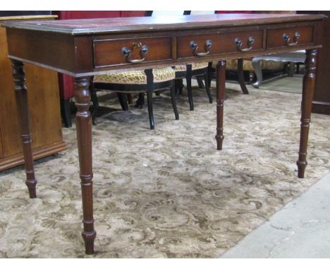 A reproduction mahogany veneered writing table of rectangular form with inset leather top over three frieze drawers and three