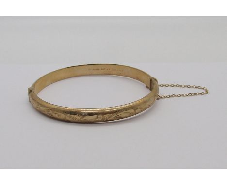 9ct hinged bangle with engraved scrolled decoration, 8.5g 