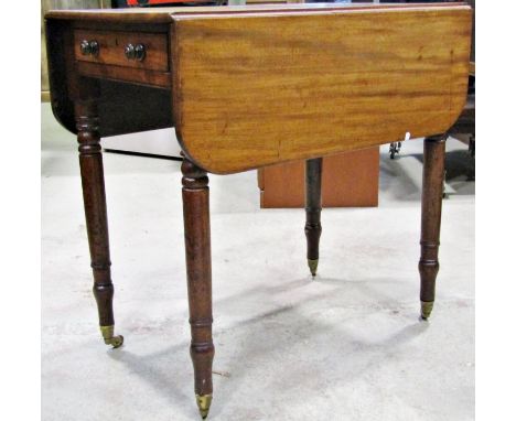 A 19th century mahogany Pembroke table with one real and one dummy frieze drawer raised on ring turned and tapered legs with 