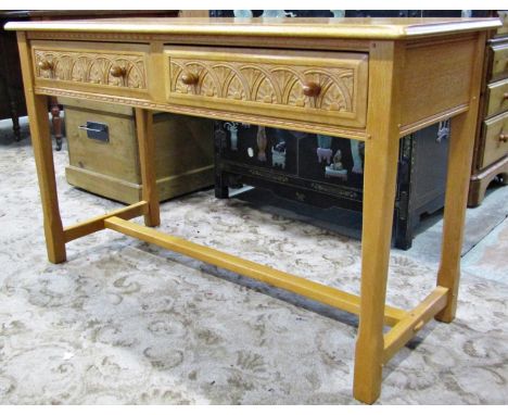 A good quality old English style light oak side table fitted with two frieze drawers with carved detail  raised on square cut