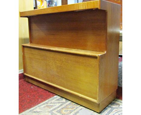 A mid 20th century teak lounge bar by Turnidge with shaped outline and partially enclosed by three doors beneath an open fixe