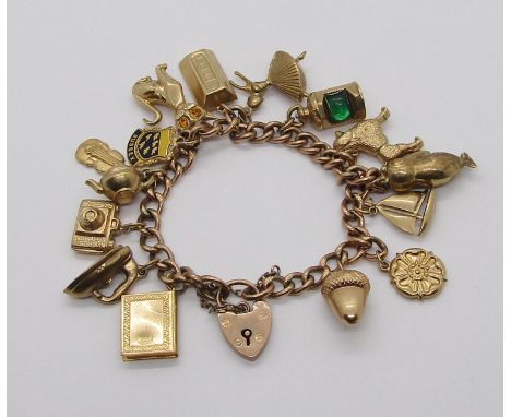 9ct curb link charm bracelet with heart padlock clasp, hung with a collection of novelty charms to include a lantern, ingot, 