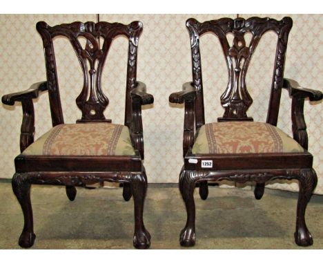 A pair of reproduction Chippendale style open armchairs with pierced splats, moulded frames and drop in upholstered seats 