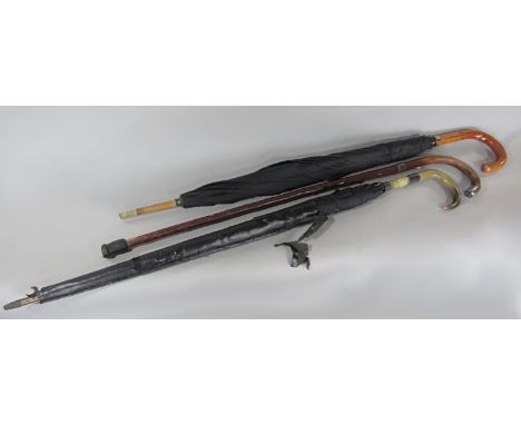 A black silk umbrella with a 9ct gold collar, another umbrella with a horn handle and a walking stick 