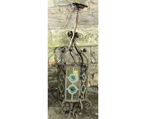 A Victorian hall/porch lantern of hexagonal form with coloured leaded light bulls eye panels within a scrolling iron work fra