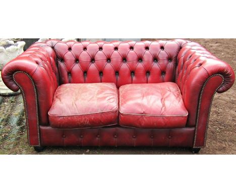 Two seat red leather upholstered and button back Chesterfield sofa with loose seat cushions, together with a matching chair 