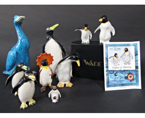 A collection of ceramic penguins including a boxed pair of Wade limited edition examples modelled by Jessie Van Hallen, a Bes