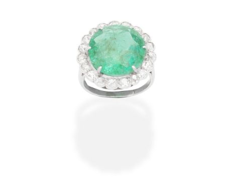 EMERALD AND DIAMOND CLUSTER RING, CIRCA 1930The circular-cut emerald set within a single and cushion-shaped diamond surround,