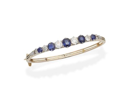 SAPPHIRE AND DIAMOND BANGLE, LATE 19TH CENTURYThe trifurcated knifewire bangle set to the front with circular and oval-cut sa