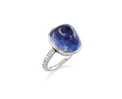 SAPPHIRE RING, FIRST QUARTER OF THE 20TH CENTURYThe cabochon sapphire between engraved foliate shoulders, mounted in platinum