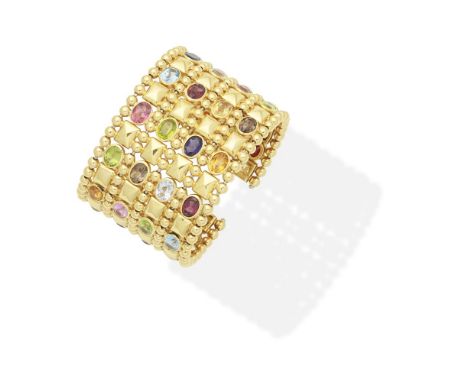 GEM-SET TORQUE BANGLEThe wide openwork bangle set with oval-cut gemstones, including topaz, iolite, peridot and citrine,  inn