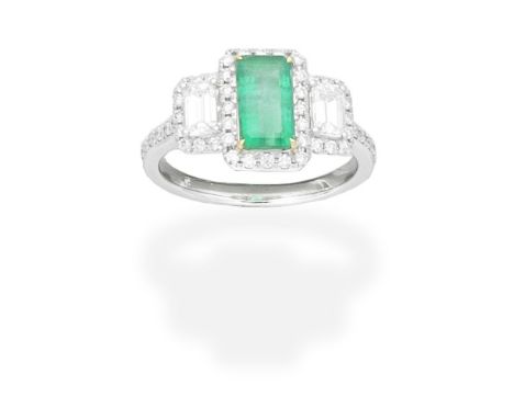 EMERALD AND DIAMOND RINGThe step-cut emerald between step-cut diamonds, within a brilliant-cut diamond surround, the shoulder