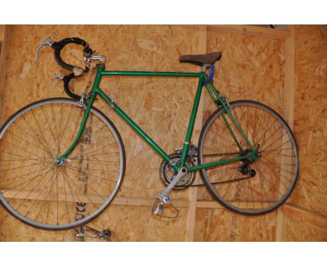 A VINTAGE GENTS RACING BIKE with a 23in frame 10speed Suntour gears (condition report overpainted in green, tyres flat)