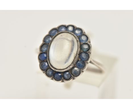 A SAPPHIRE AND MOONSTONE DRESS RING, a principally set oval cabochon moonstone set with a surround of circular cut sapphires 