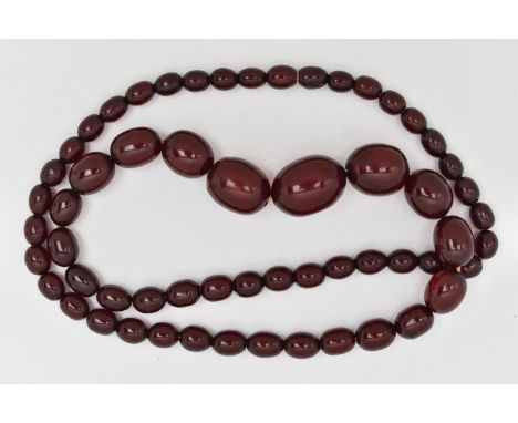 A CHERRY BAKELITE BEAD NECKLACE, a single row of oval graduating beads, largest measuring 22.2mm x 16.3mm, smallest measuring