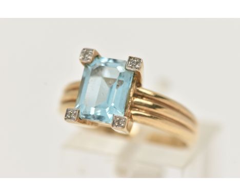 A 9CT GOLD TOPAZ AND DIAMOND RING, centering on a rectangular cut blue topaz, four claw set with four single cut diamond acce