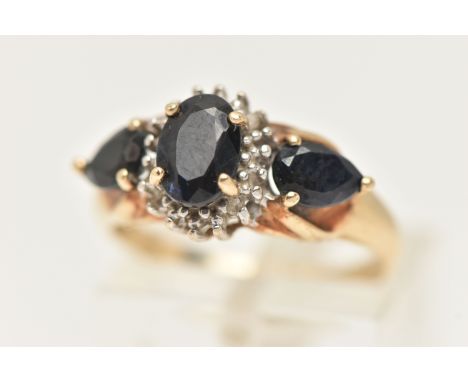 A 9CT GOLD SAPPHRIE AND DIAMOND RING, set with a central oval cut deep blue sapphire four claw set within a surround of singl