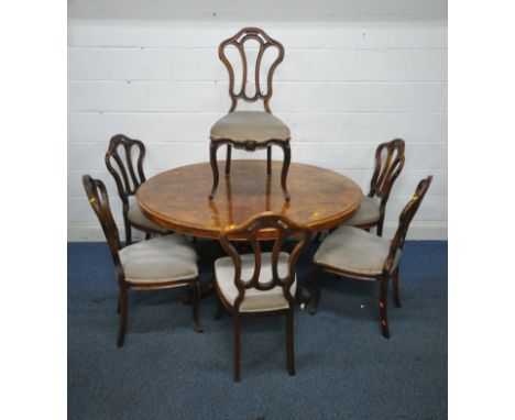 A VICTORIAN BURR WALNUT OVAL TILT TOP LOO TABLE, raised on four turned supports and scrolled legs, with ceramic castors, widt