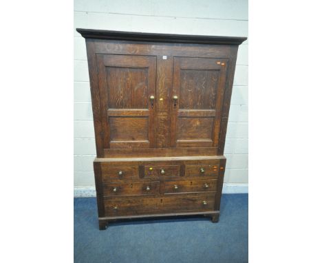 A GEORGIAN OAK WELSH CUPBOARD, fitted with double doors, atop a base with three dummy drawers, above three drawers, raised on