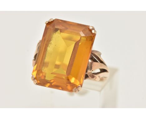 A YELLOW METAL SYNTHETIC ORANGE SAPPHIRE DRESS RING, set with a large rectangular step cut orange stone, assessed as syntheti