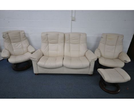 A CREAM LEATHER STRESSLESS SUITE, comprising a pair of swivel reclining armchairs, one with a footstool, and a two seater sof