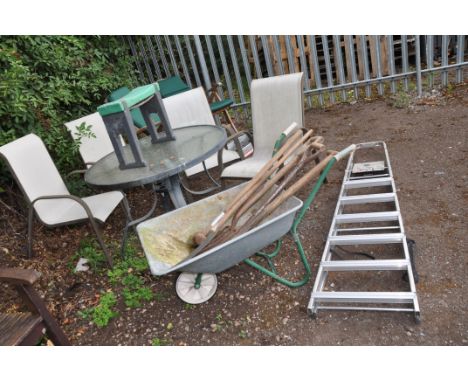A GLASS TOPPED METAL GARDEN TABLE 103cm in diameter, four similar chairs, a wheel barrow, garden tools and an aluminium step 