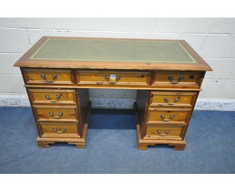 A LATE 20TH CENTURY PINE TWIN PEDESTAL DESK, with a green leather writing surface, nine assorted drawers, raised on bracket f