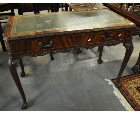 Reproduction walnut writing desk having leather inset top above two drawers with brass loop handles, carved frieze, standing 