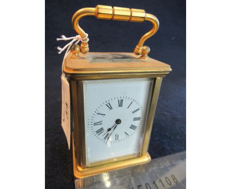 Miniature brass carriage clock with bevelled glass panels, Roman numerals and white face. (B.P. 21% + VAT) No key. Not curren