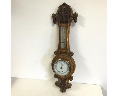 A 1920s oak wall barometer with carved finial and pendant (67cm x 20cm)