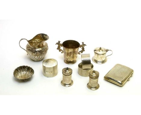 A selection of silver items, to include: napkin rings, condiments, shell salt, cigarette case, cream jug and two handled cup.