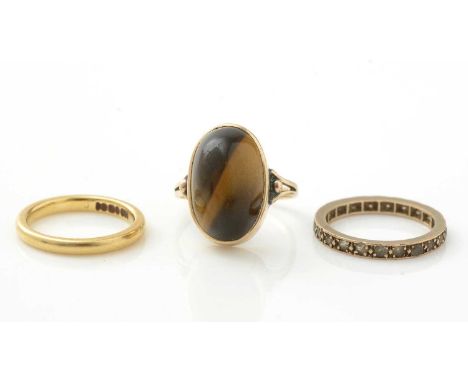 An 18ct yellow gold wedding band, 3.1g; a tiger's eye ring, 9ct gold mount and shank, ring size K, 3.7g gross; and a white st