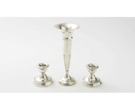 A silver trumpet vase, with filled base; and a pair of silver dwarf candlesticks, with weighted bases. 