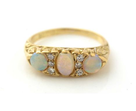 An opal and diamond ring, the three graduated opal cabochons parted by diamond pairs, in 18ct yellow gold scrolling mount and