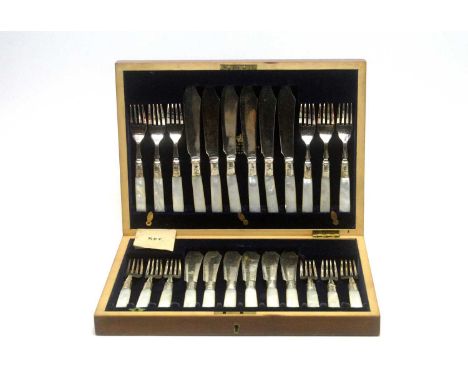 A set of twelve fish knives and forks, with silver ferrules and mother-of-pearl handles, in mahogany canteen. 