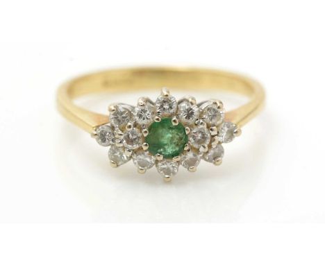 An emerald and diamond cluster ring, the circular facet cut emerald surrounded by brilliant cut diamonds, 18ct yellow gold mo