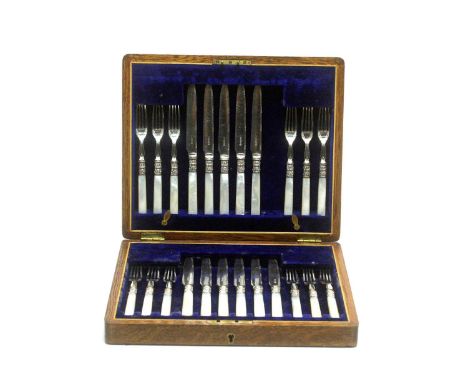 A set tea knives and forks, twelve forks and eleven knives, with silver ferrules and mother-of-pearl handles, in oak canteen.